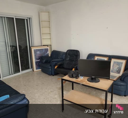 חדר עם ספות, שולחן ומסך מחשב